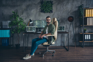 Photo of serious confident young guy dressed khaki shirt glasses computer engineering indoors...