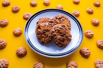 chocolate cookies on a plate and yellow background