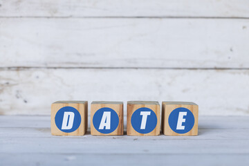 date concept written on wooden cubes or blocks, on white wooden background.