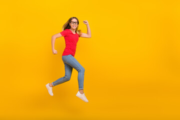 Full size profile side photo of young girl hurry speed runner jumper motion isolated over yellow color background
