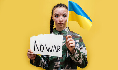 Ukrainian girl kid in military uniform with dirty face protesting war conflict raises banner with...