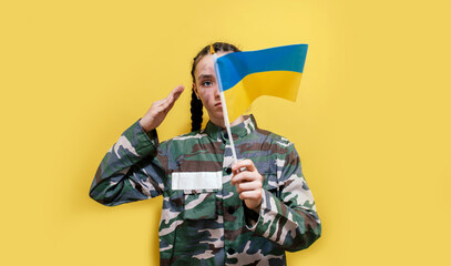 Fototapeta na wymiar Ukrainian girl kid in military uniform with a dirty face, salutes. Child against war