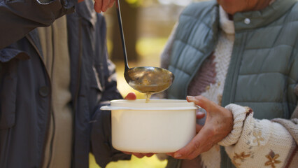 Senior Caucasian couple getting food nature background aged people wellbeing support concept focus on hands, container and ladle closeup selective focus . High quality photo