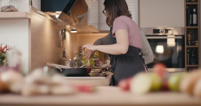 Senior and young woman cooking family dinner together at home kitchen