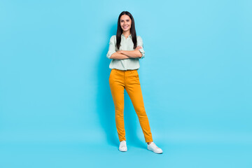 Full body photo of young cheerful woman crossed hands representative isolated over blue color...
