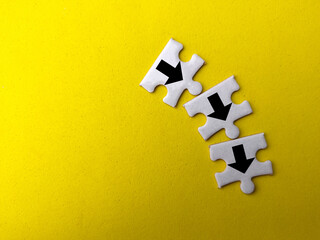 Top view white puzzle with arrow icon on a yellow background.