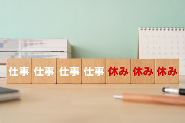 週休3日のイメージ｜積み木や本が置かれたオフィスのデスク