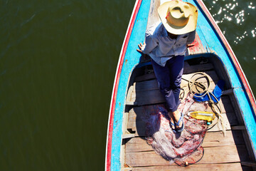 Waiting for the perfect catch. Thai fisherman waiting patiently on his longtail boat - Thailand.