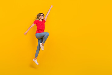 Fototapeta na wymiar Full body profile side photo of youth active girl jump power hero look empty space isolated over yellow color background