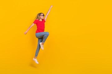 Full body profile side photo of youth active girl jump power hero look empty space isolated over yellow color background