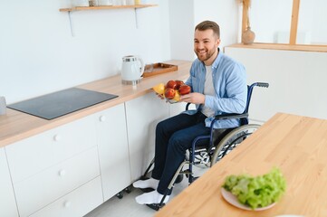 thoughtful young disabled man on wheelchair at home