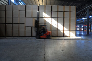 Workers drive forklifts to transport density board products in the factory, North China