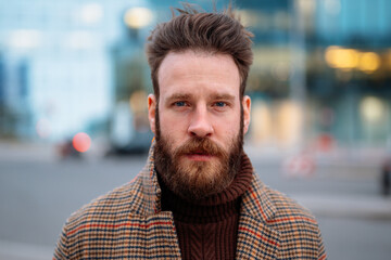 Close up portrait of hipster man in business centre area. Looking to camera