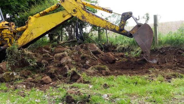 Yellow Digger digging out foundations for an extinction to a bungalow