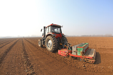 Obraz premium Farmers drive planters to plant peas in the fields, North China