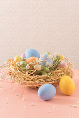 Easter eggs in nest on pink background.