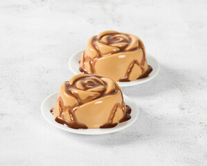Vegan Coffee Panna Cotta with chocolate topping, in the shape of a rose, on a plate. Light gray background