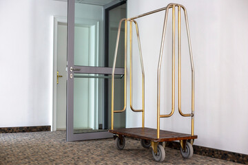 Empty luggage cart stands near the wall. Empty metall baggage trailer 
