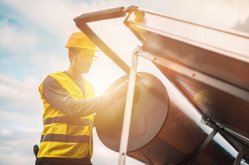 Man assembles solar panel for hot water in a roof