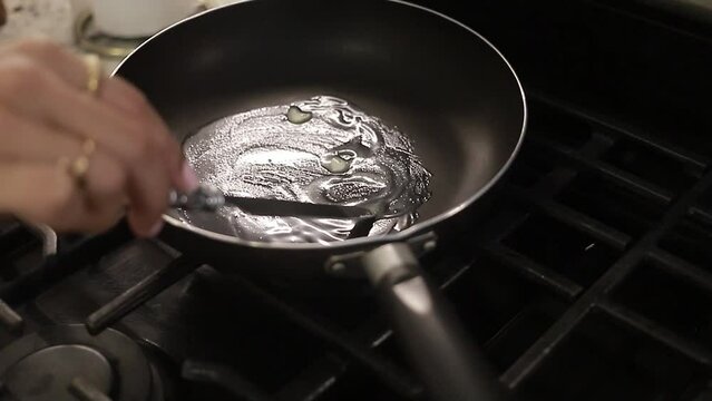 chica joven preparando la sart&eacute;n con mantequilla para preparar el desayuno, la comida en casa.