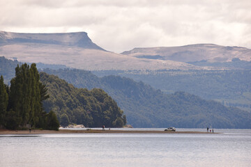 Mesmerizing view of the calm lake water flowing under the hills with dense vegetation