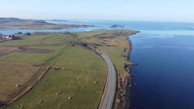 Road E39 along Norway coast is surrounded by green grasslands and going down into subsea tunnel Byfjordtunnel - Stavanger Rogaland aerial