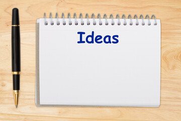 Ideas message on a notebook with a pen on a desk