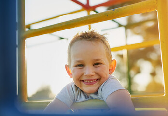 Playtime in the park. Portrait of a smiling little boy playing on a jungle gym in the park.