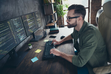Profile side view portrait of attractive focused intellectual guy nerd tech support typing html at...