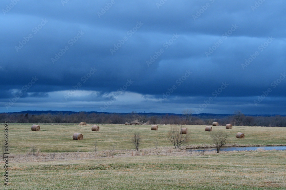 Wall mural Storm Clouds Over a Hay Field