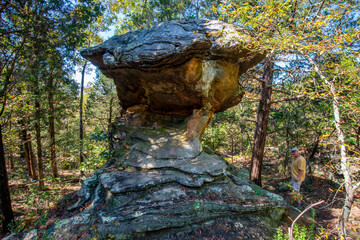 towering rock formation in an Autumn forest with the photographer in the background. Shawnee National Forest Illinois