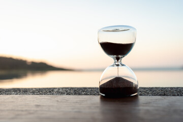 Hand holding the hour glass with sea background. time to relax and summer concepts.