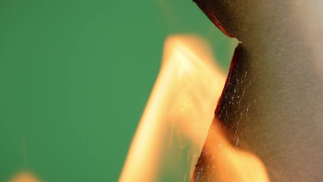 Transition. White paper is on fire on a green background.