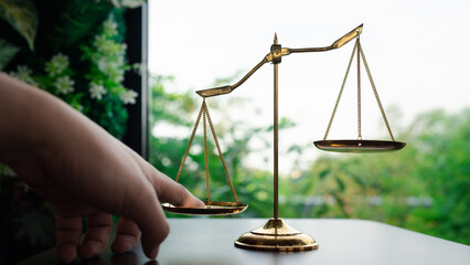Tip the scales of justice concept as a the hand of a person illegally influencing the legal system for an unfair advantage. - obrazy, fototapety, plakaty