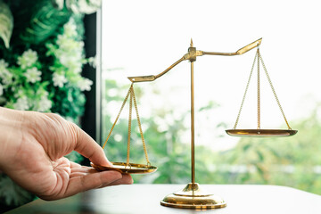 Tip the scales of justice concept as a the hand of a person illegally influencing the legal system...
