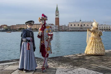 Fototapete Karneval View of two women and a man in carnival clothing standing against a body of water in a harbor  © Nicola Zanella/Wirestock Creators