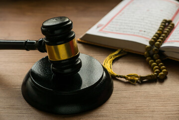 Sharia or Islamic law concept with gavel ,Quran and rosary beads on wooden background.