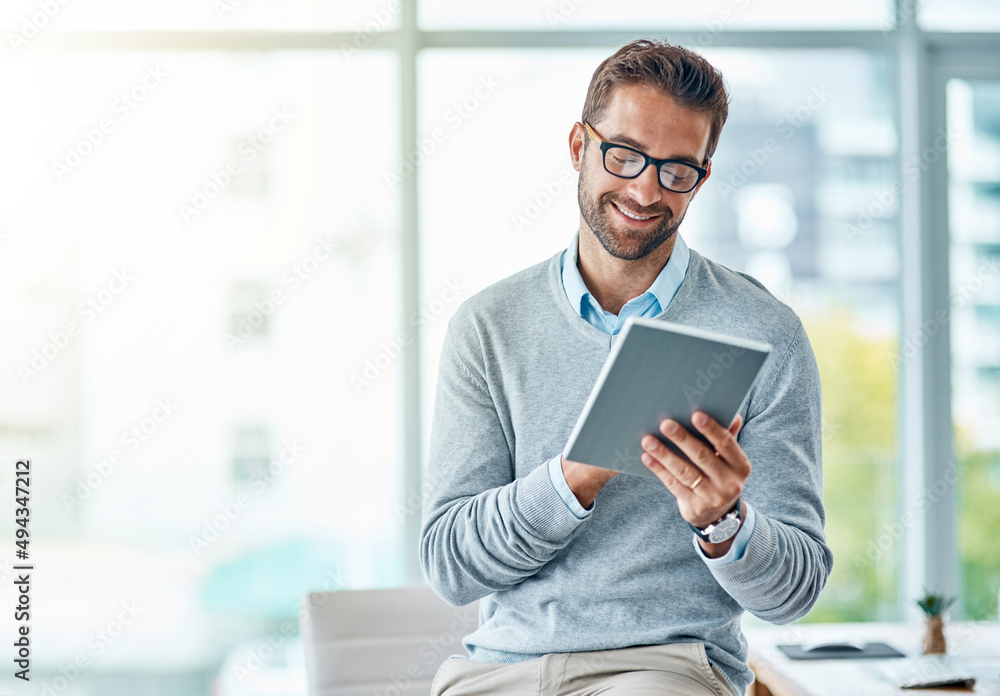 Poster he knows how to handle business the smart way. shot of a young businessman using a digital tablet in