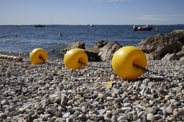 Yellow border buoys on rocky beach