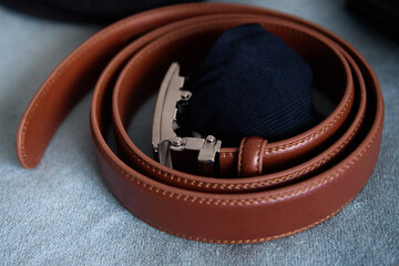 Brown leather belt and blue socks on a carpet