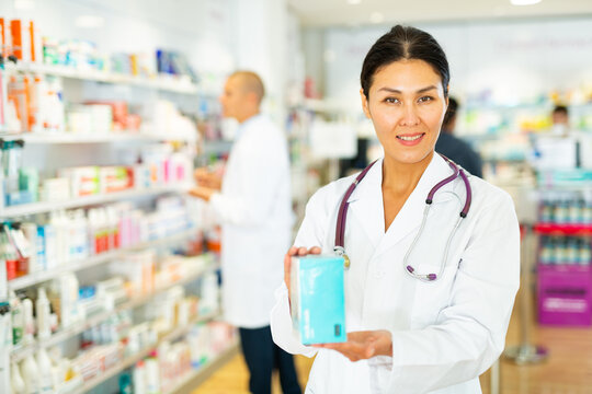 Positive female pharmacist offers various body care medicines