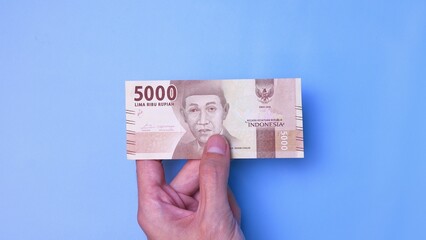 Indonesian Rupiah the official currency of Indonesia. Man's hand is making a payment. Business Loan...