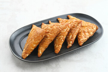 Tempeh, Tempe Goreng or Fried tempeh is Indonesia traditional food, made from fermented soybean seeds. Salty and savory, served as a side dish or snack. Served on plate.
