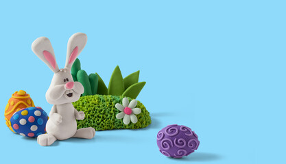 Easter greeting card with cute bunny and easter eggs. Handmade from plasticine on a blue background with copy space
