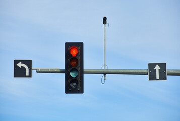Red light in North America. A surveillance camera is also in the picture. Day.