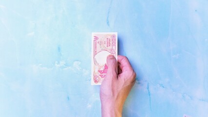 Indonesian Rupiah the official currency of Indonesia. Man's hand is making a payment. Business Loan...