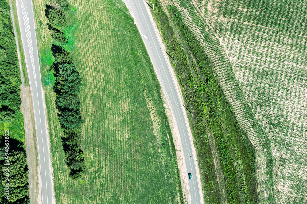 Wall mural asphalt roads pass through green countryside landscape. aerial overhead view.