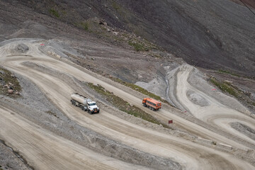 Fuel truck on dangerous gravel mountain road transporting diesel fuel to Kumtor gold mine. Industry freight truck transportation.