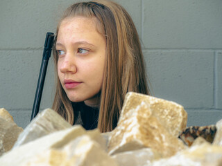 caucasian blond teen aged soldier girl  on a checkpoint holding a rifle gun and wearing a camo...