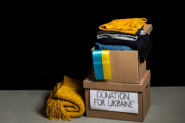 Box with donation clothes for ukrainian refugees suffering from war. Charity and Helping poor and...